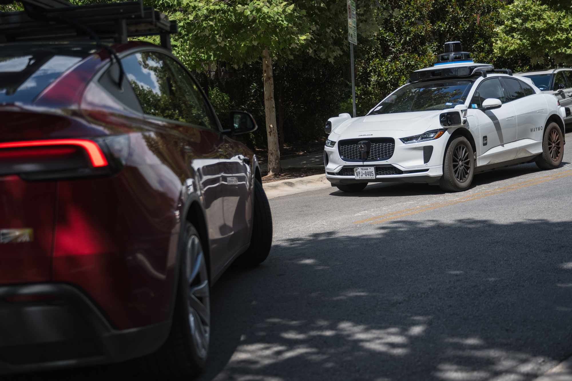A Waymo autonomous taxi, right, and a vehicle Tesla is using for robotaxi testing purposes in Austin, Texas, US, on Friday, June 20, 2025. Elon Musk said Tesla Inc. has set June 22 as a tentative launch date for the start of its robotaxi network.