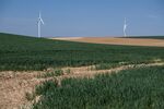 Wheat grows in a crop field near wind turbines in Aisne, France.