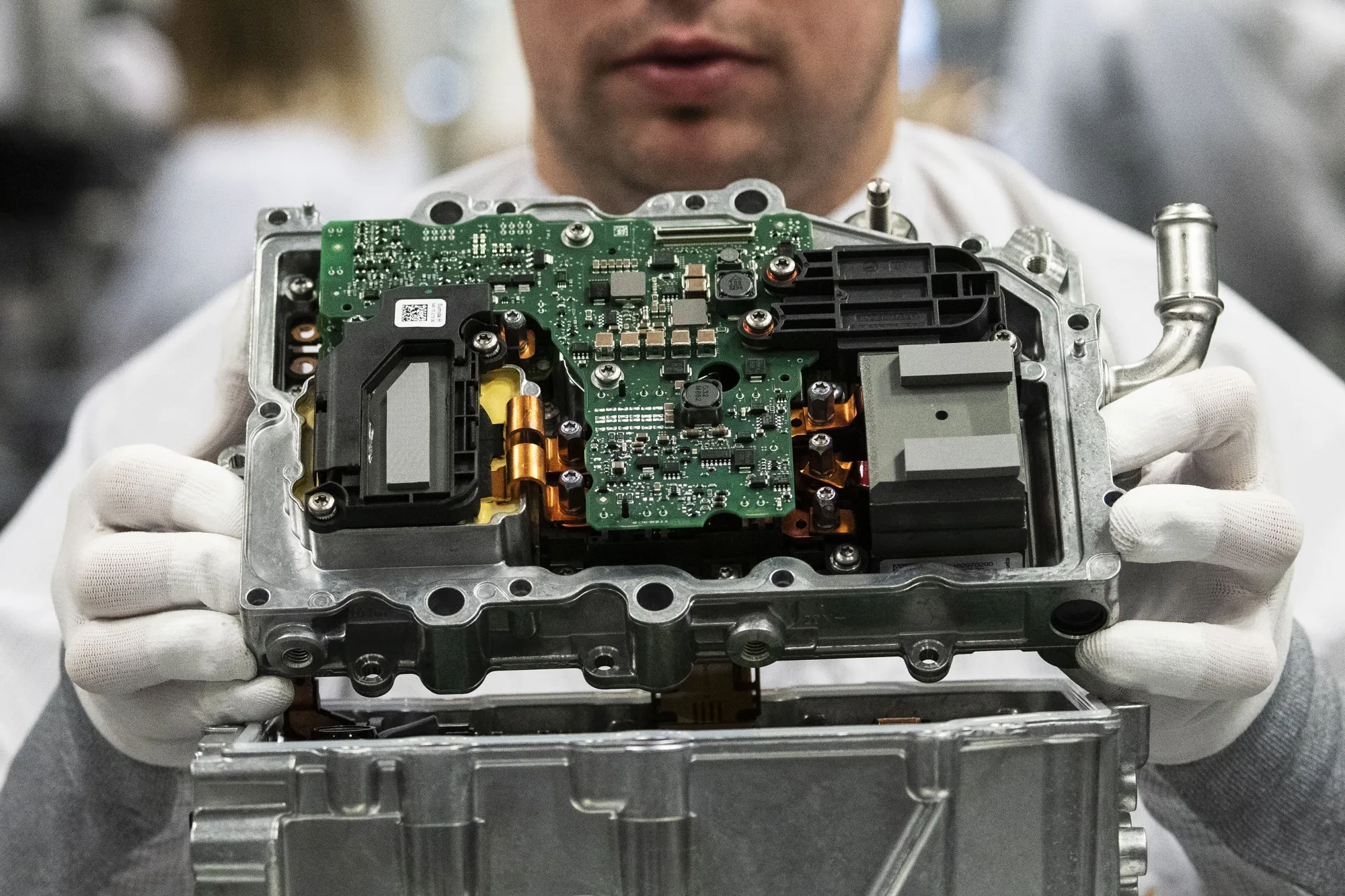 A DC/DC converter component for hybrid and electric vehicles inside the Continental automotive powertrain factory.