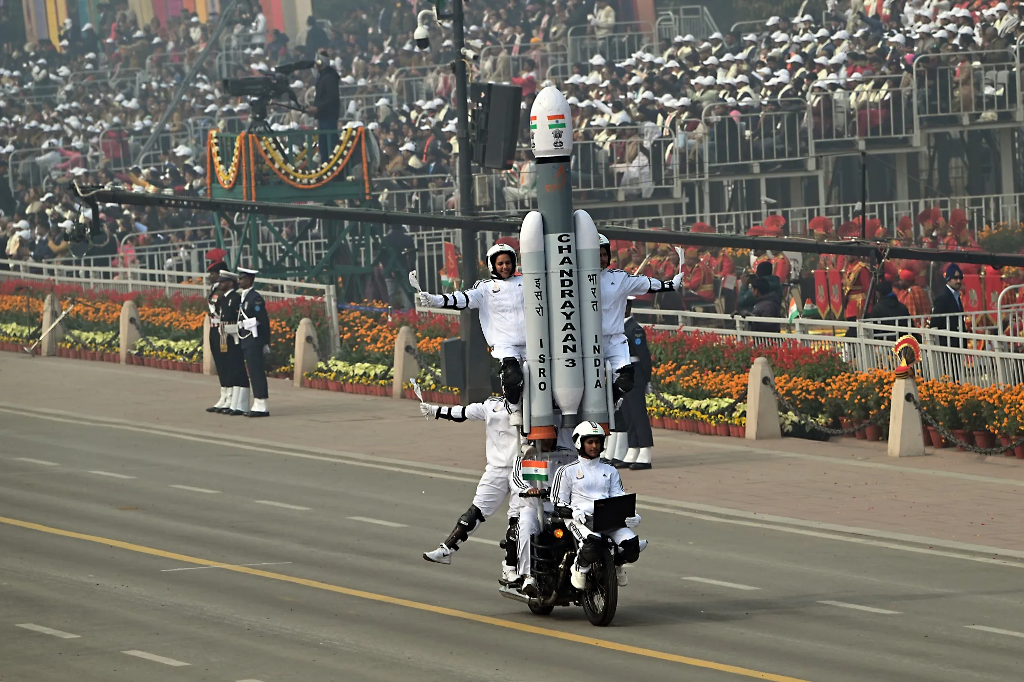 Acrobats carry a model of India's Chandrayaan-3 during the Republic Day parade in New Delhi in 2024.&nbsp;