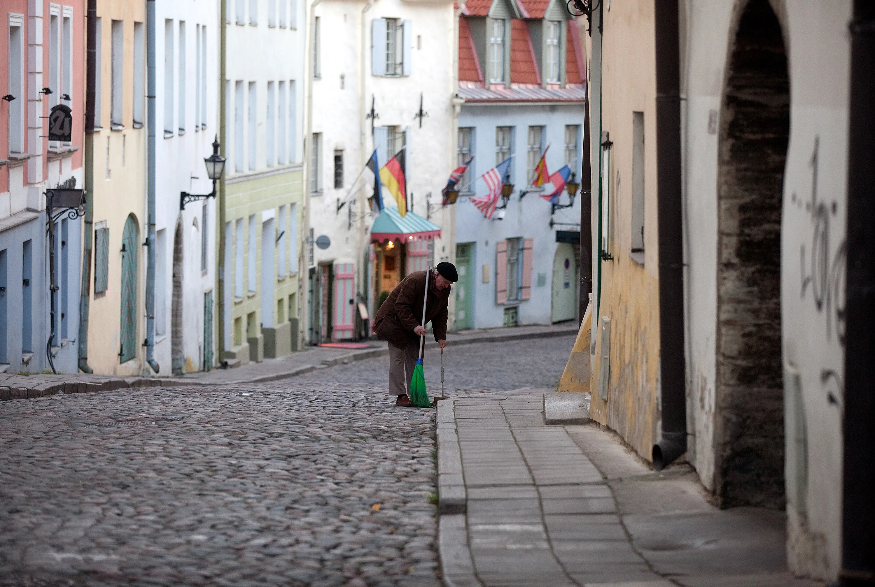 A man uses a brush to sweep the cobbled street in the old town area of Tallinn, Estonia, on Wednesday, Nov. 16, 2011.
