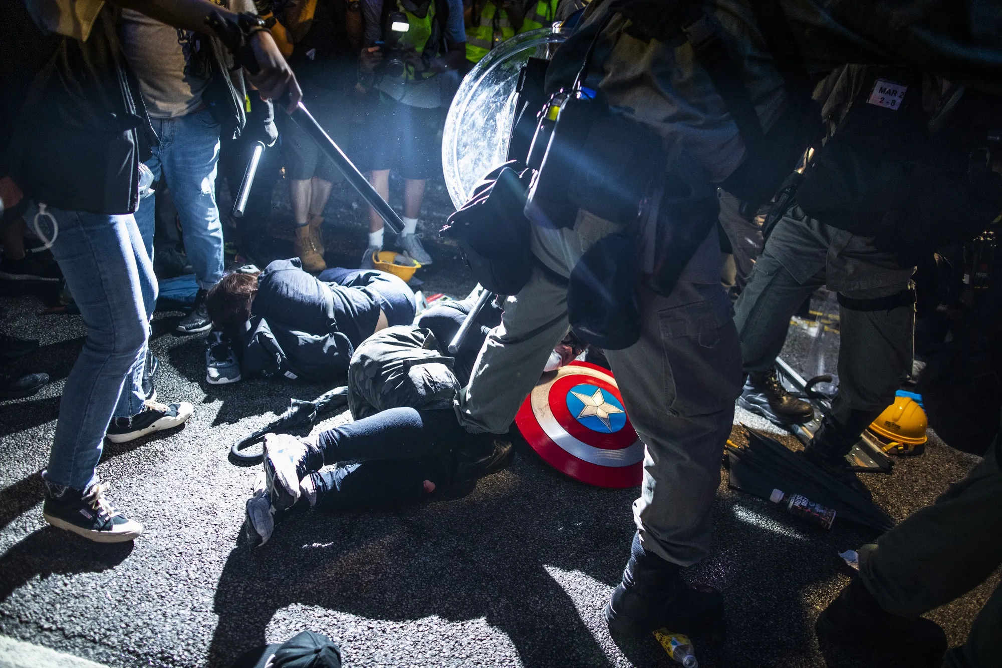 Riot police stand around demonstrators lying on the ground during a protest in the Yuen Long district of the New Territories in Hong Kong, China, on Saturday, July 27, 2019.&nbsp;