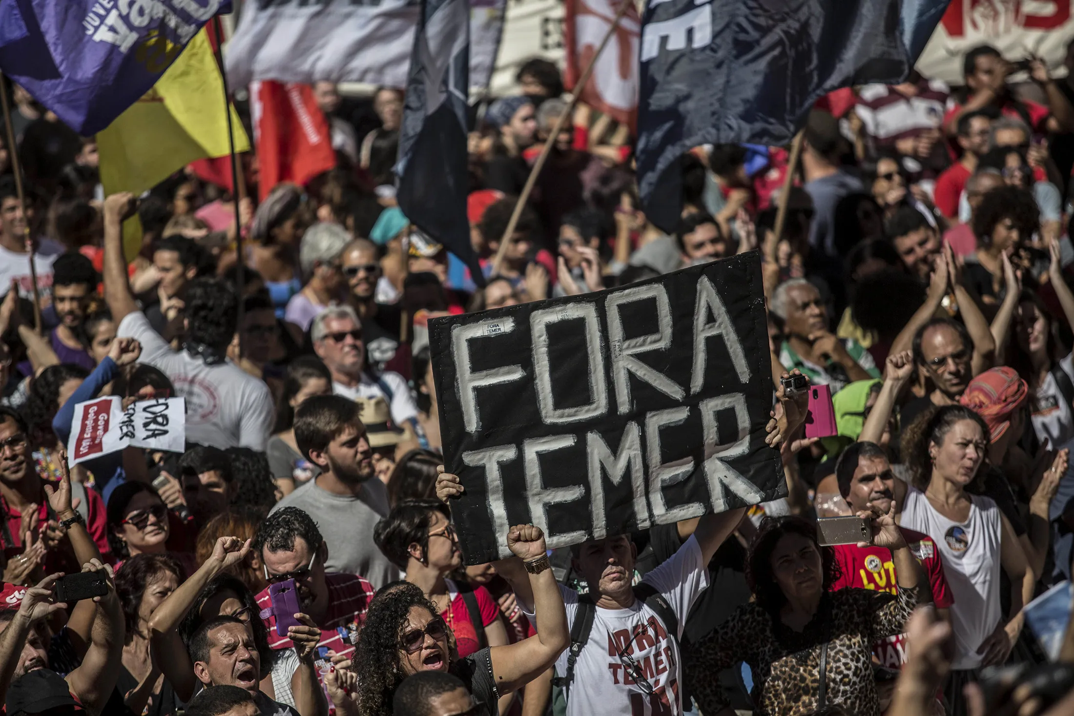 A demonstrator holds up a sign that reads 'Out Temer' during a workers union protest against President Michel Temer's government on Labor Day in Rio de Janeiro, Brazil, on May 1, 2017.
