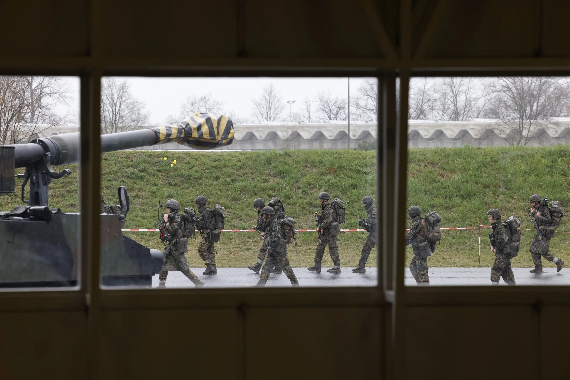 Soldiers of the Swiss army walk past a tank in Thun, Switzerland.