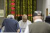 Investors stand at trading terminals in front of an electronic stock board at a securities brokerage in Shanghai, China, on Wednesday, May 30, 2018.