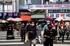 Pedestrians wearing protective masks cross a road in Daejeon, South Korea, on Friday, June 5, 2020. South Korea has refrained from imposing a full lockdown to contain the virus outbreak, instead relying on mass testing and loose social distancing rules.