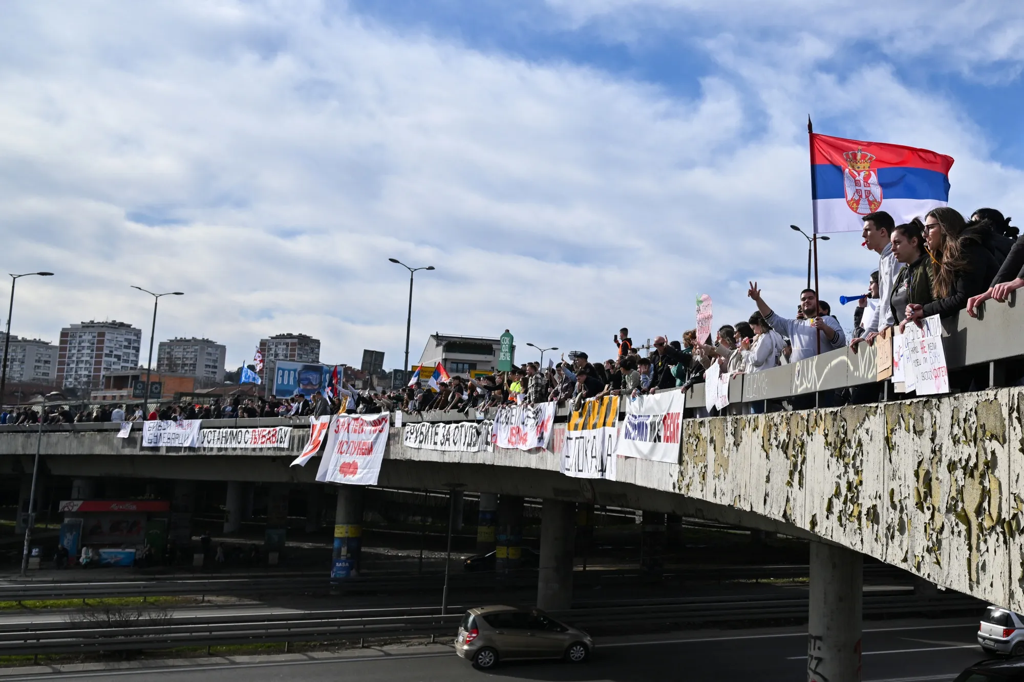 Protesters wave to passing drivers in Belgrade&nbsp;on Jan. 27.