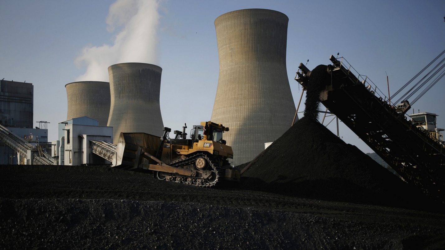A bulldozer moves coal that will be burned to generate electricity at a power plant.
