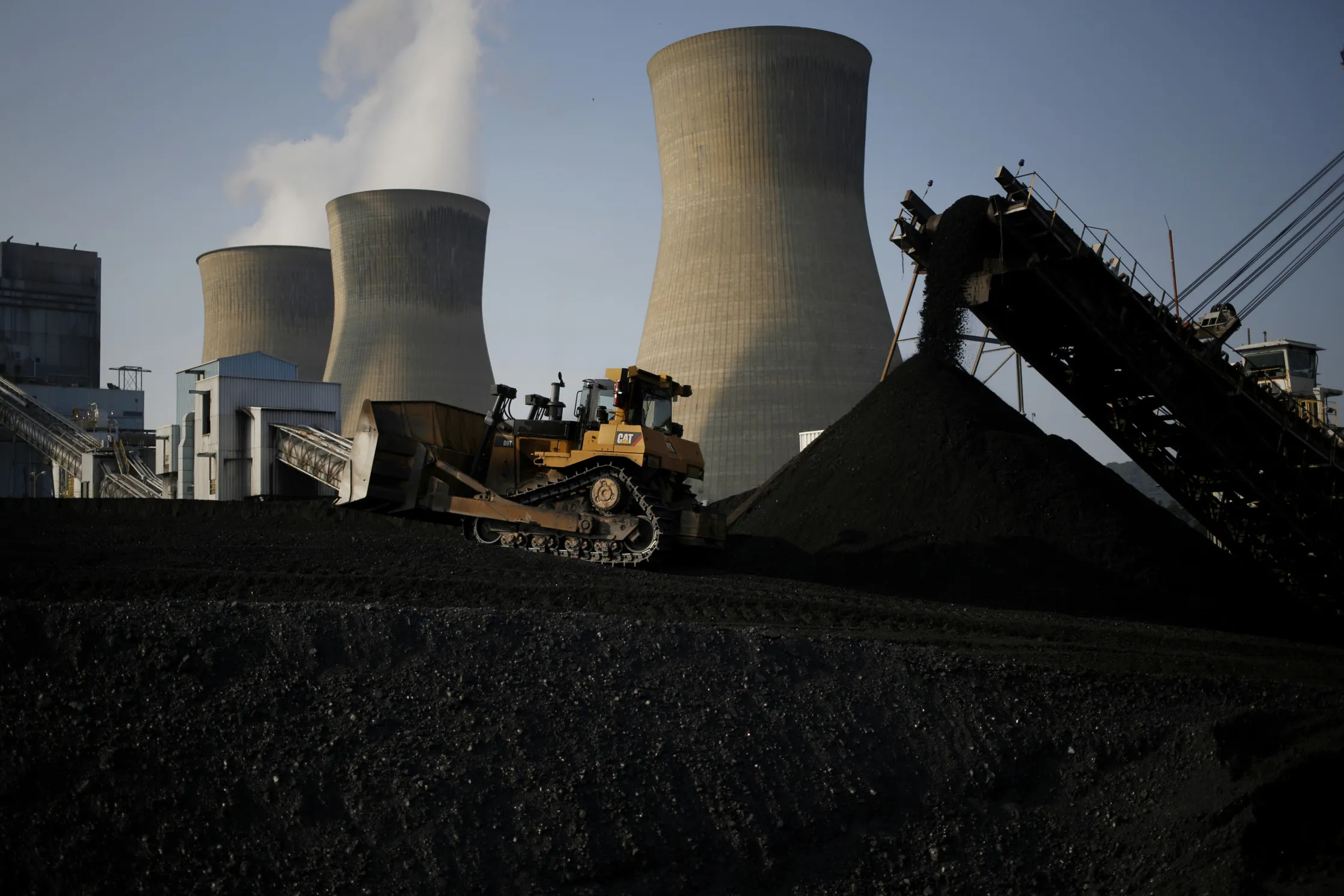 A bulldozer moves coal that will be burned to generate electricity at a coal-fired plant in Winfield, West Virginia.