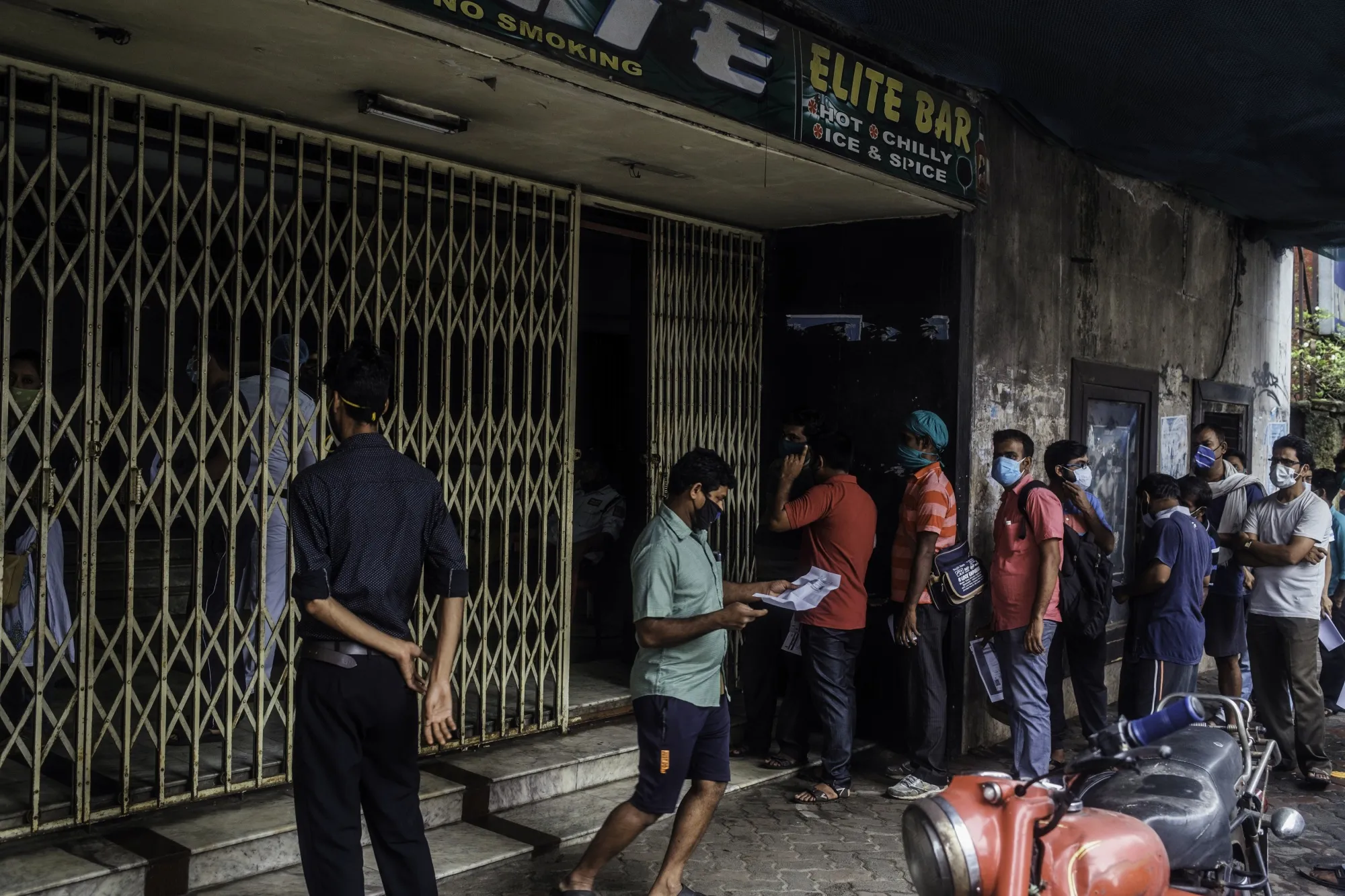 People wait in line at a vaccination center set up at the Elite Cinema Hall in Kolkata.