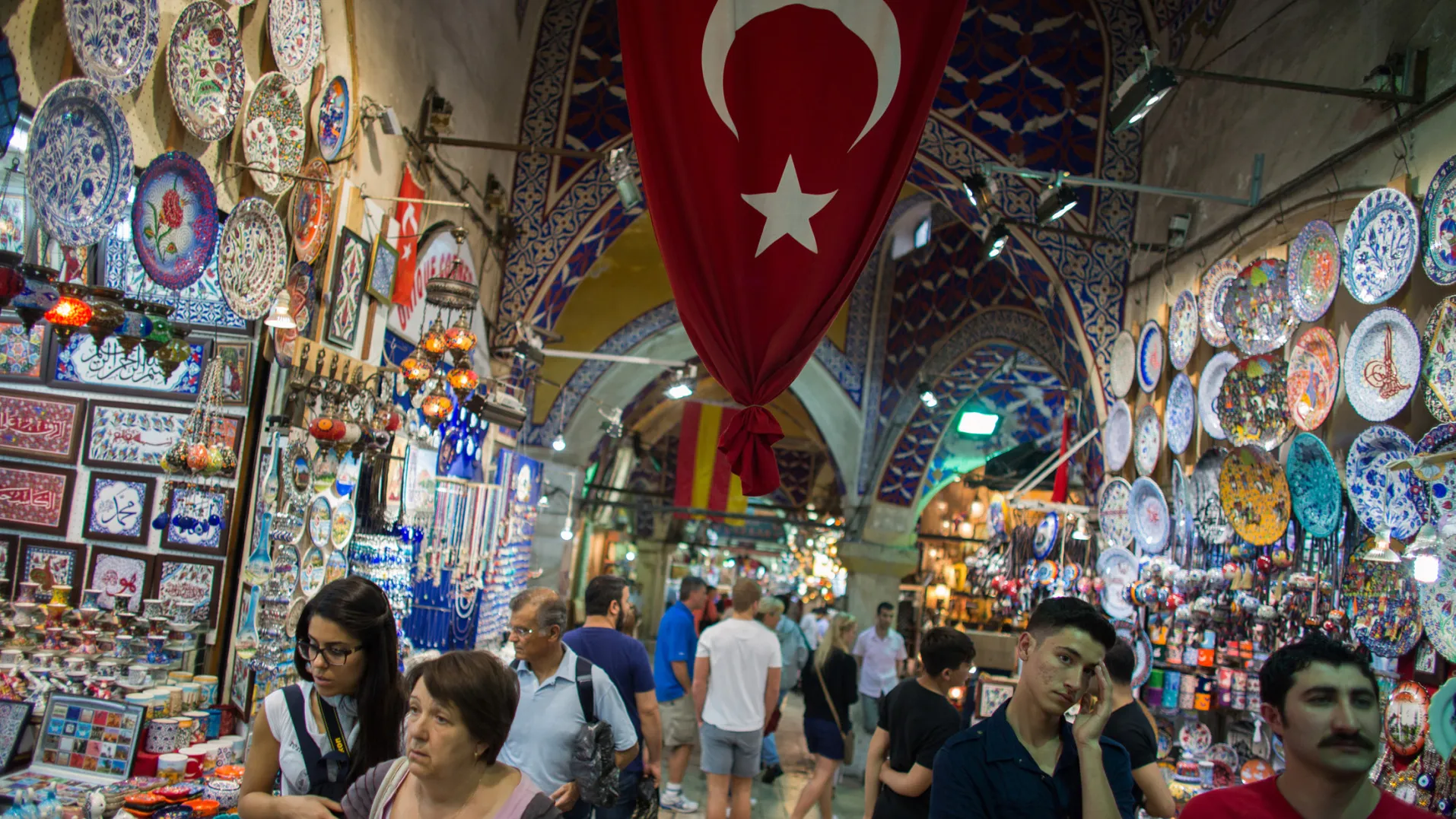 A Turkish national flag hangs above stores in the Grand Bazaar market in Istanbul, Turkey.
