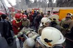 Firefighters carry a wounded colleague in downtown Tehran on Jan. 19.
