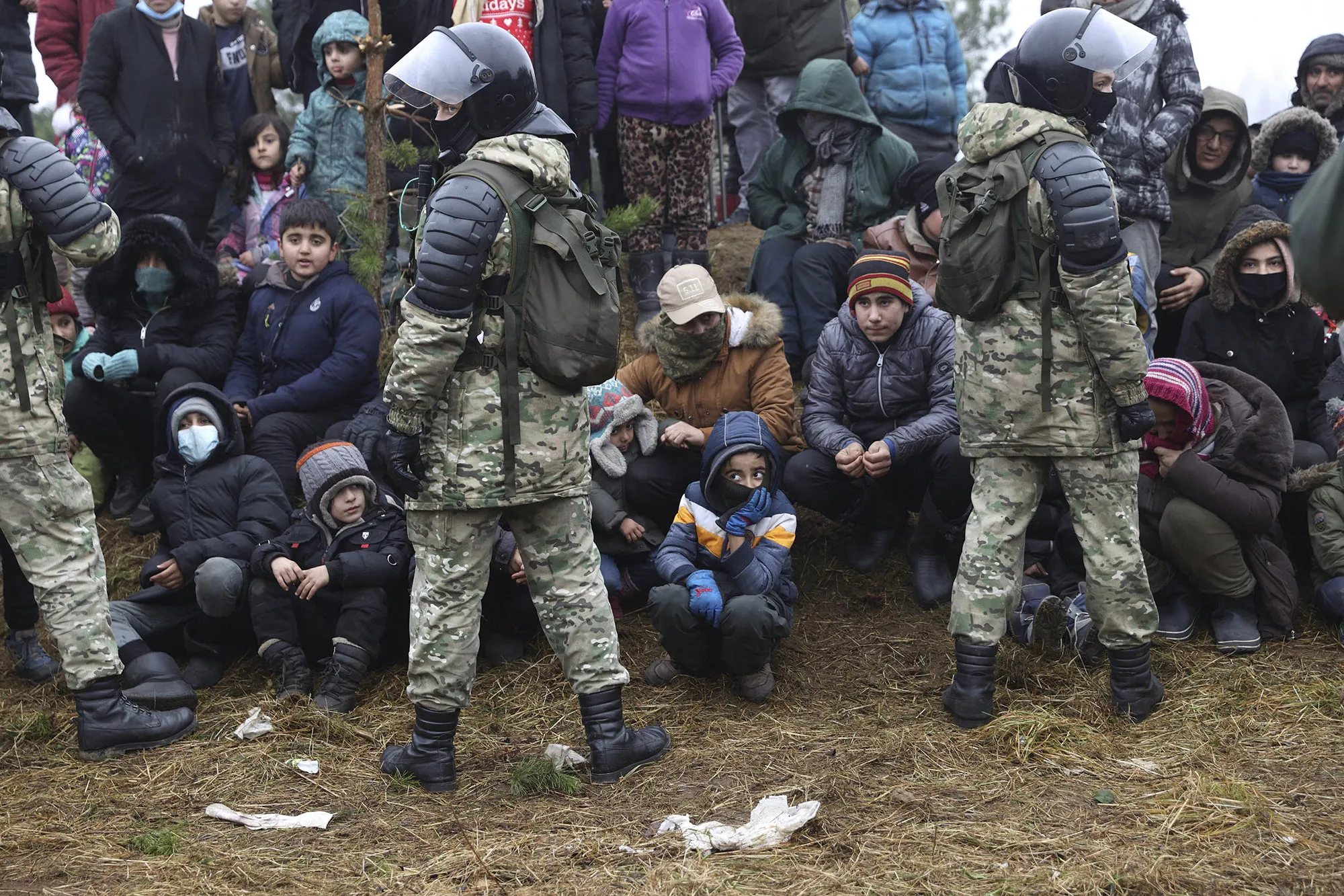 Belarusian security personnel face migrants near the Belarus-Poland border in Grodno, on Nov. 14.