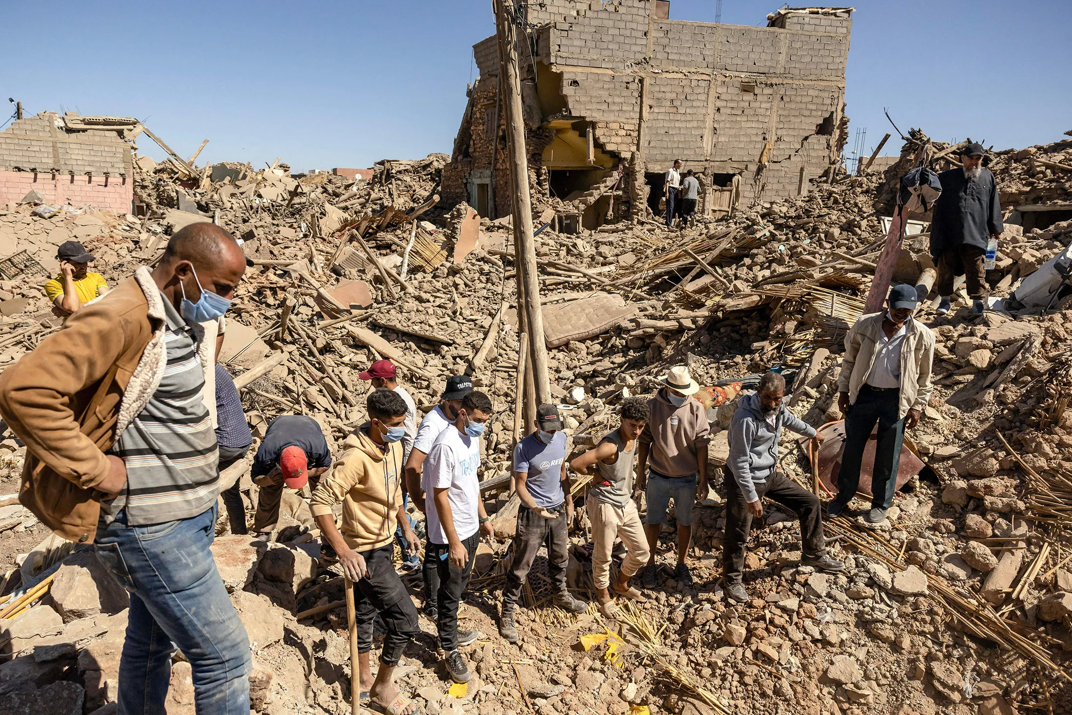 Volunteers watch as a digger moves rubble of collapsed houses in Tafeghaghte, 37 miles southwest of Marrakesh, on Sept. 10.