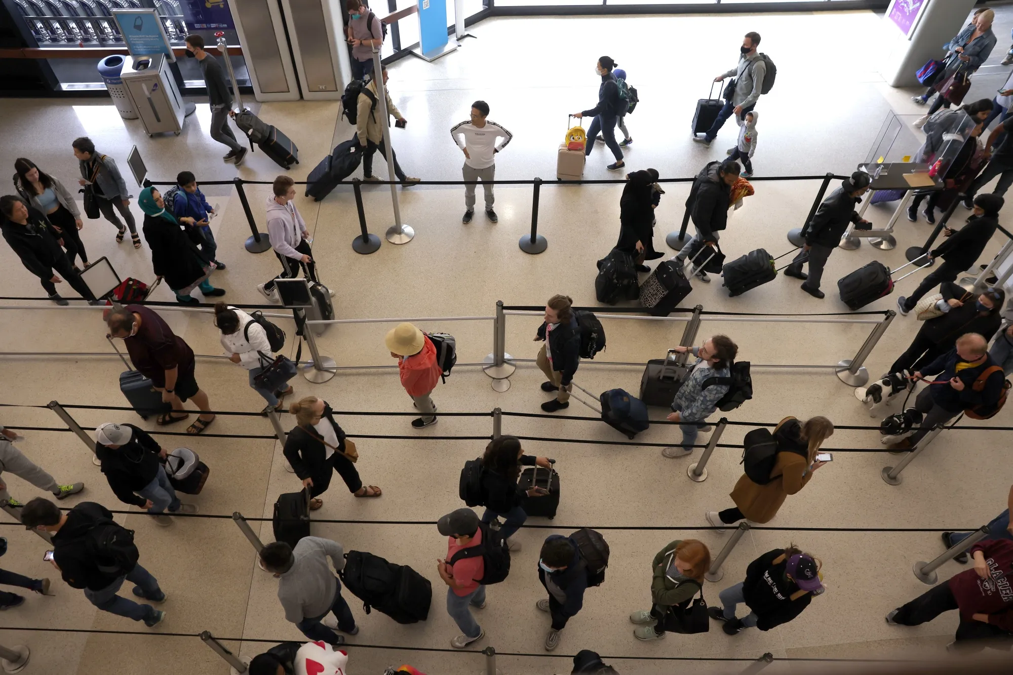 Travelers line up to enter a security checkpoint at San Francisco International Airport.
