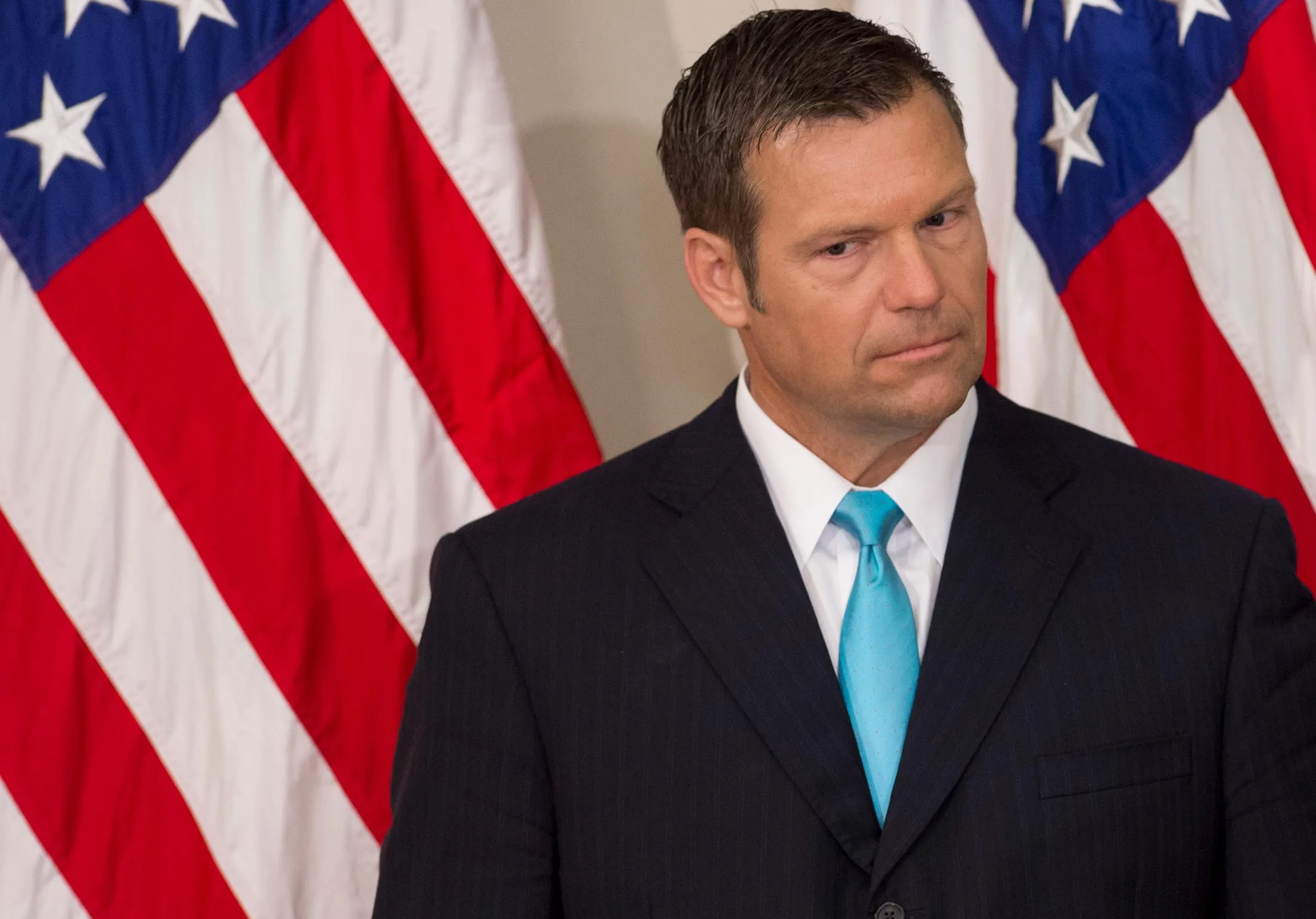 Kansas Secretary of State Kris Kobach listens as President Trump speaks at the first meeting of the Presidential Advisory Commission on Election Integrity in Washington on July 19, 2017.&nbsp;