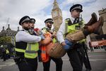 Police officers arrest an Insulate Britain protester at Parliament Square on Oct.&nbsp;12.&nbsp;