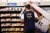 An employee moves a TCL Corp. television in shopping cart at a Wal-Mart Stores Inc. location in Burbank, California, U.S.
