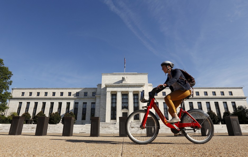 A cyclist passes the Federal Reserve in Washington, D.C.