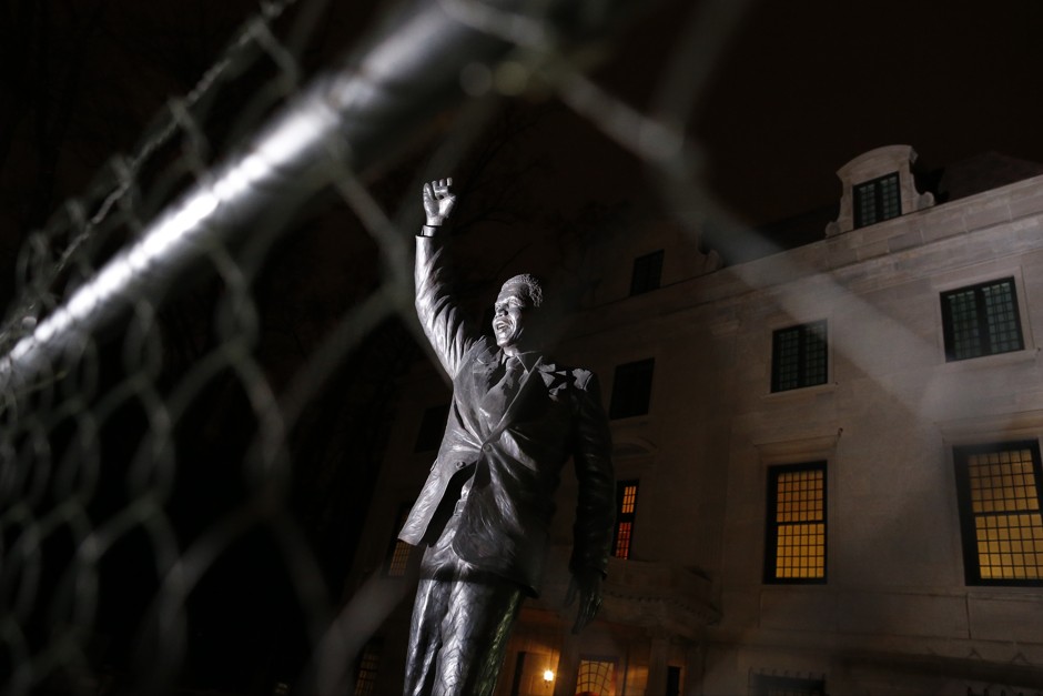 A statue of Nelson Mandela stands behind a fence at the South African Embassy in Washington.
