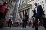 Pedestrians pass in front of the New York Stock Exchange.