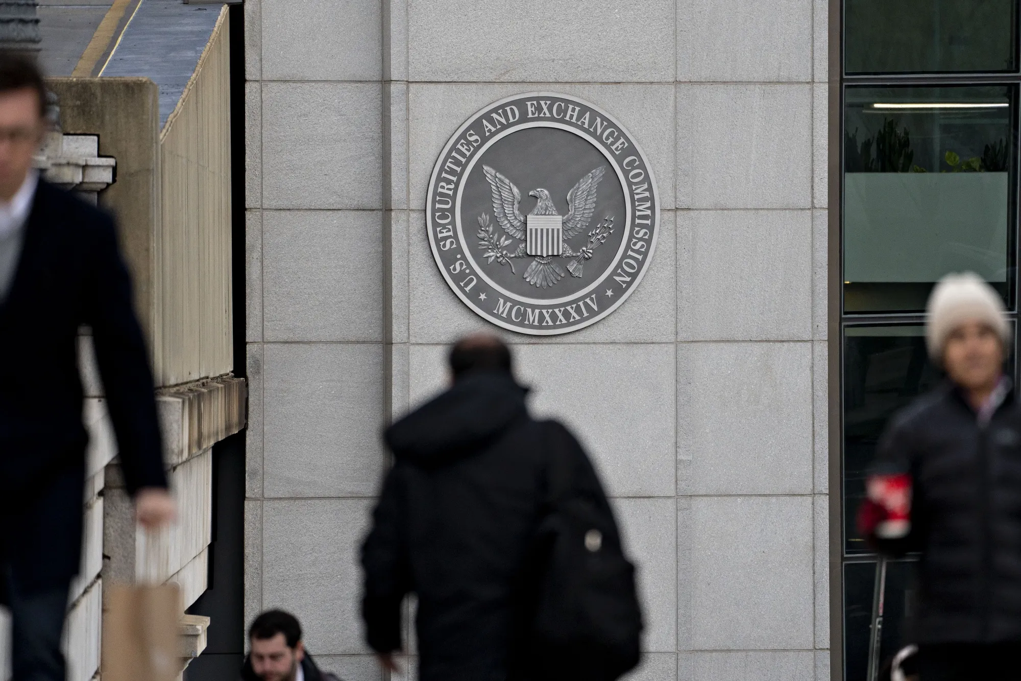 Pedestrians walk near the U.S. Securities and Exchange Commission headquarters in Washington, D.C.