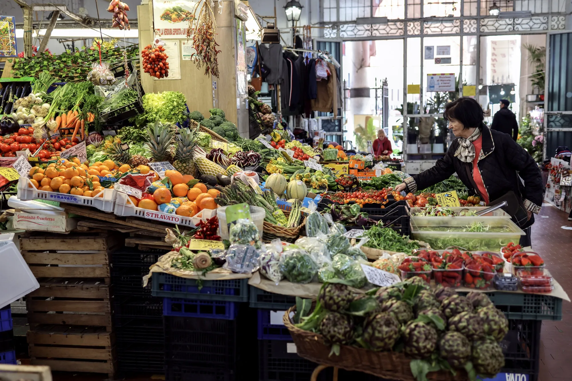 Customers shop at an indoor market in Rome, Italy.