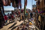 Tourists walk past a camel along a bazaar alley in Gharb Suhail, Egypt.