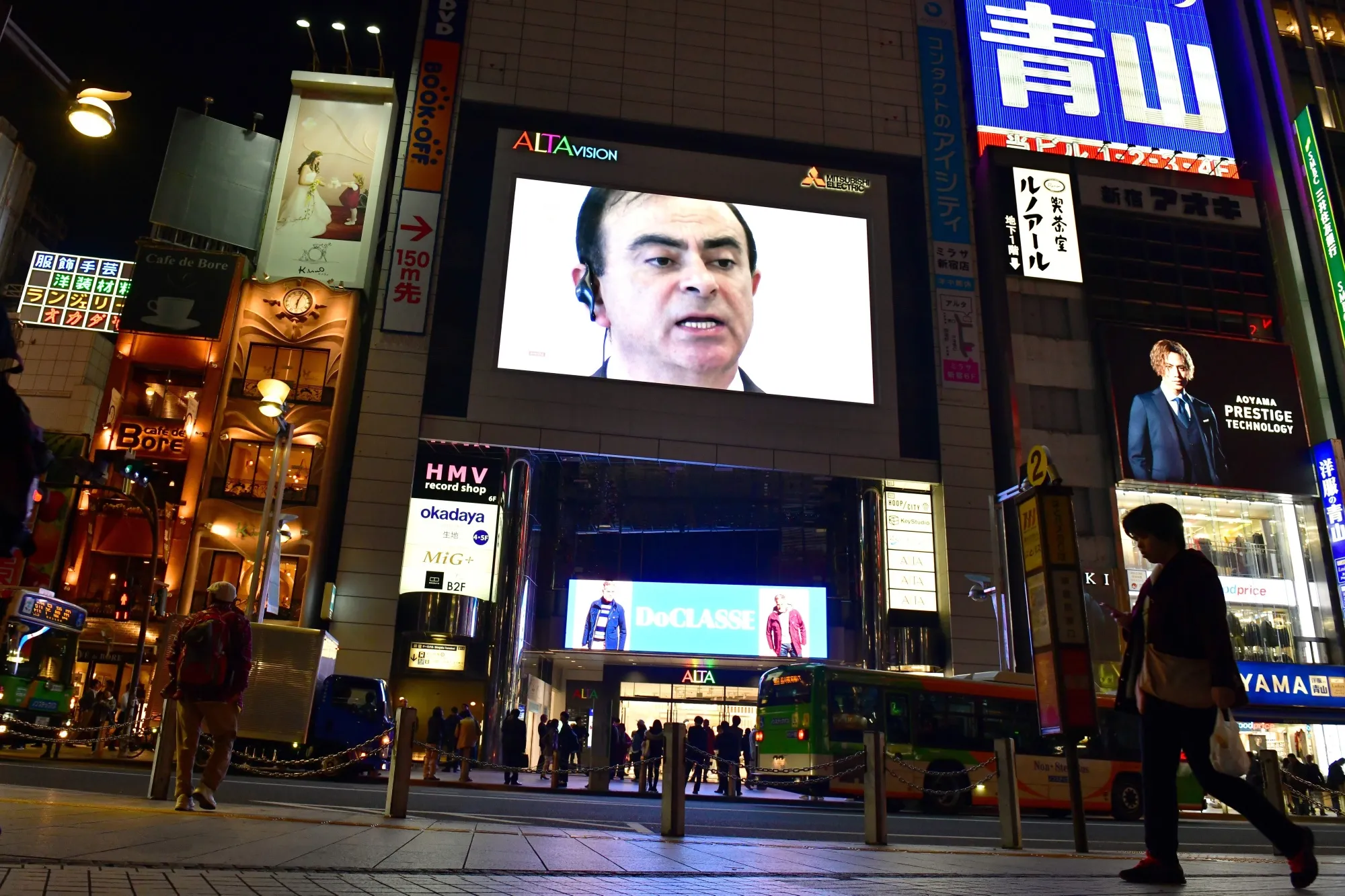 A large screen displays an image of Carlos Ghosn, in Tokyo, in Nov. 2018.