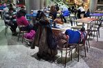 A homeless man sleeps while stranded travelers pass the time in the food court atrium in Terminal B of LaGuardia Airport.