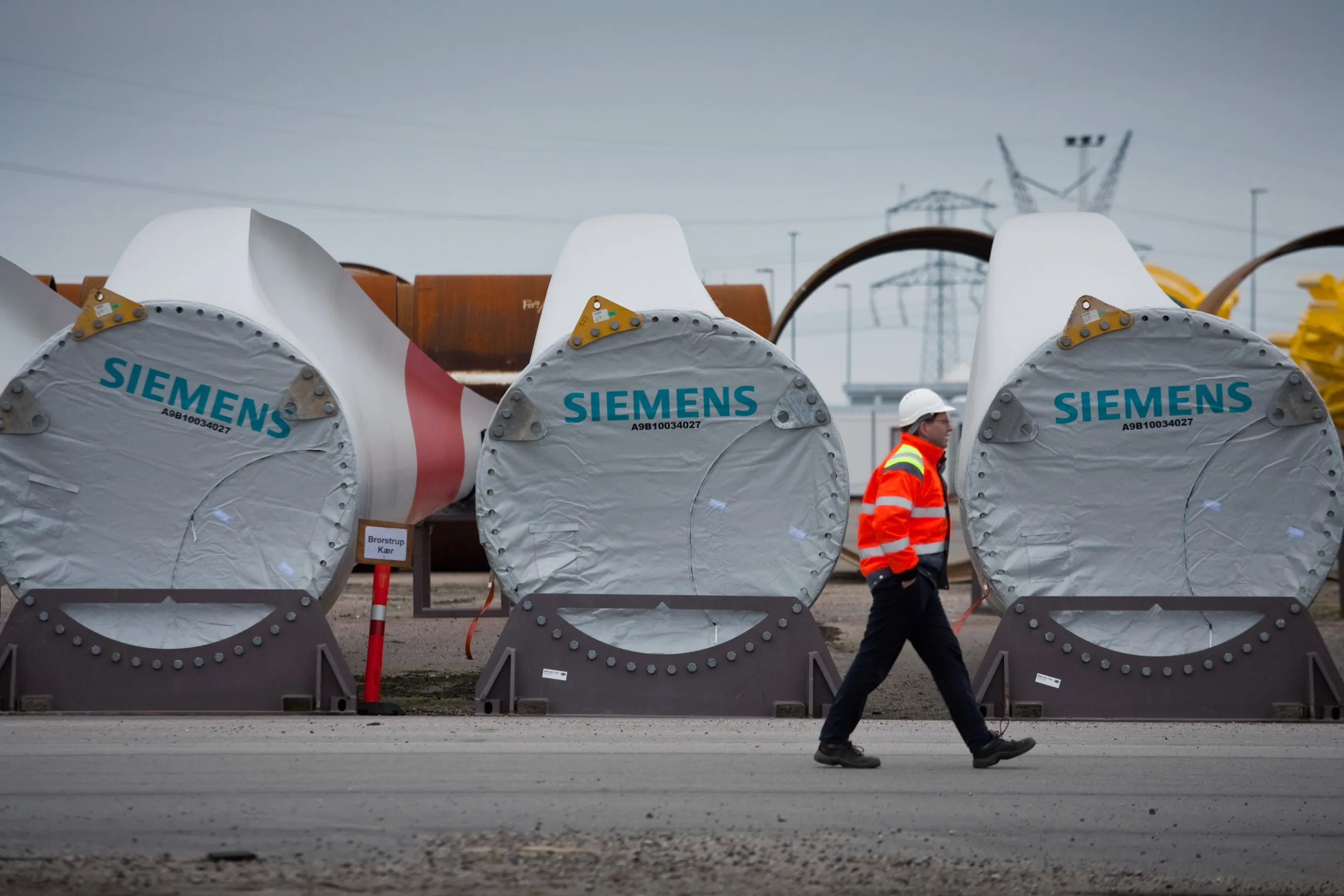 An employee passes finished turbine blades at a Siemens plant.