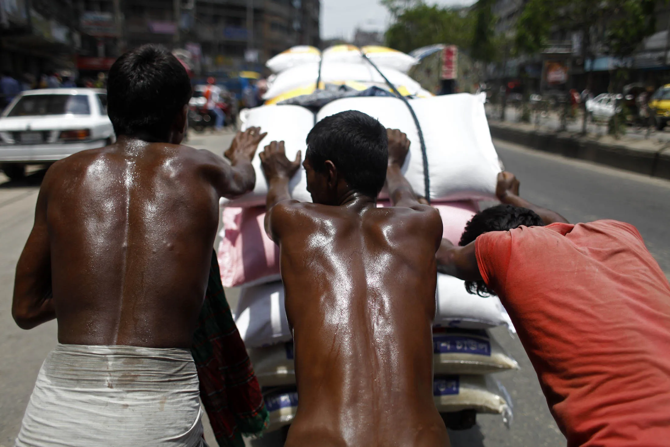 Laborers sweat profusely during the summer heat in Dhaka, Bangladesh. As many as 43 countries, especially those in Asia, including China, Indonesia, and Malaysia, will experience declines in their economies because of heat stress.
