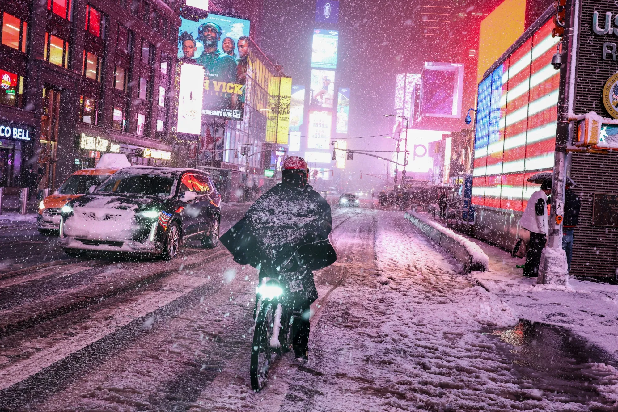 A person rides a bike along Manhattan’s Times Square during a snowfall in New York City on Feb. 22.