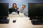 Kelli Cauley (left) a worker with Kentucky's health insurance exchange, helps Paul Coomer apply for insurance at a public library in La Grange, Kentucky on Oct. 21 2013