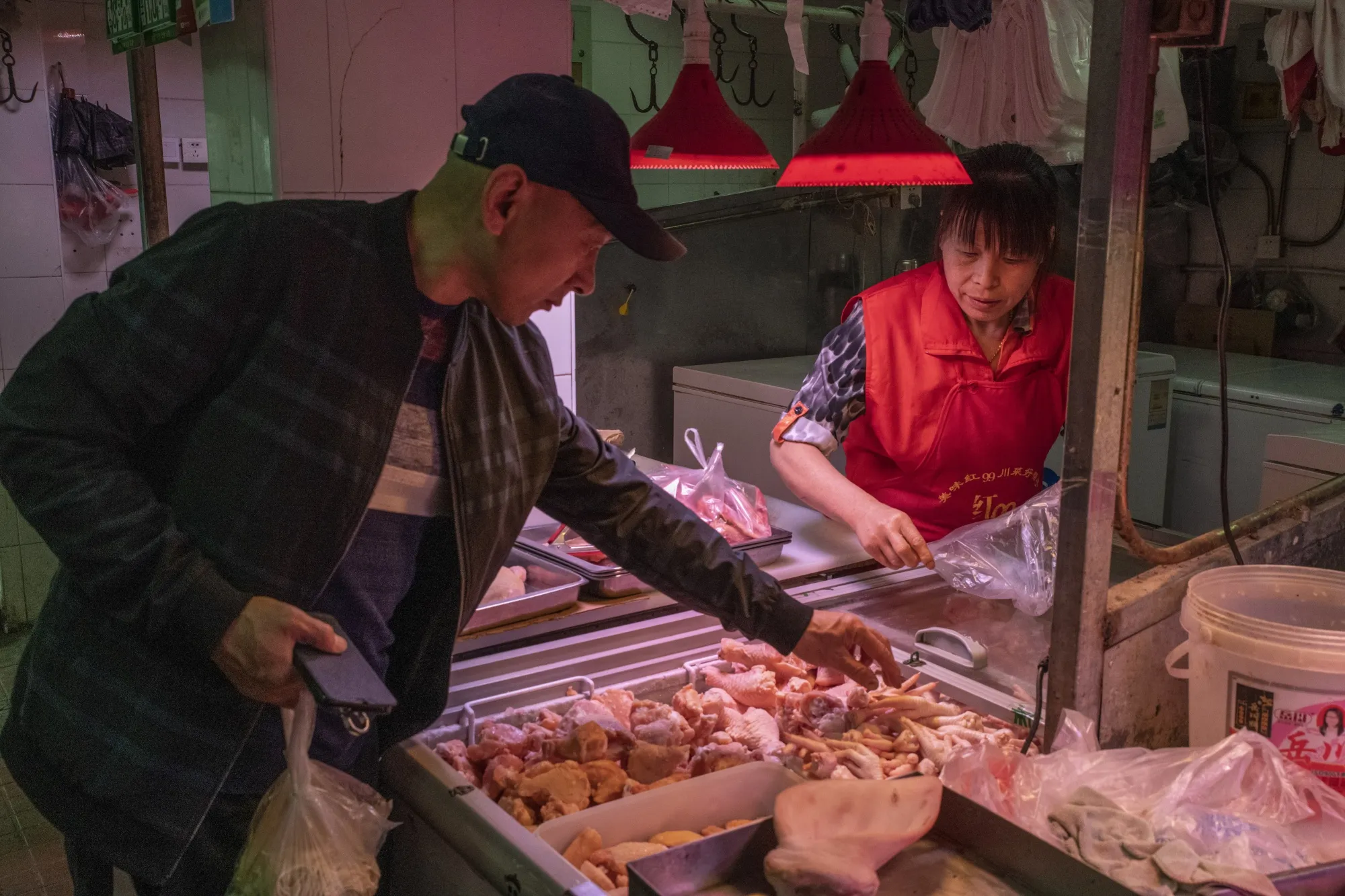 A customer selects chicken feet at a market stall in Beijing.