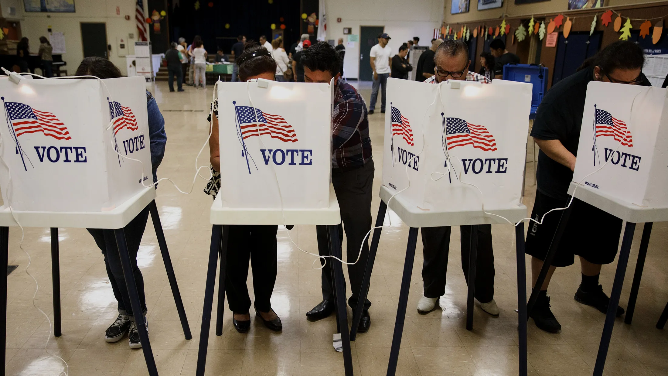 Voters cast ballots at the Brooklyn Avenue Elementary School in Los Angeles, California, U.S., on Tuesday, Nov. 8, 2016. Fifty-one percent of voters nationally were bothered a lot by Republican Donald Trump's treatment of women, while Democrat Hillary Clinton's use of private e-mail while secretary of state was troubling to 44 percent, according to preliminary exit polling as voting neared a close in some states.
