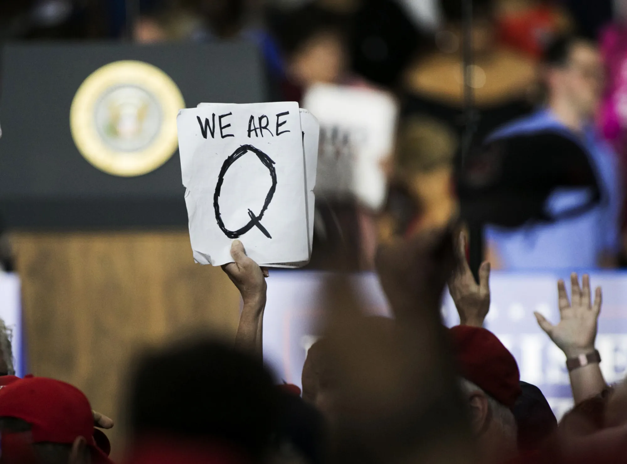 An attendee holds a QAnon sign before the start of a rally with&nbsp;Donald Trump in Lewis Center, Ohio in 2018.&nbsp;
