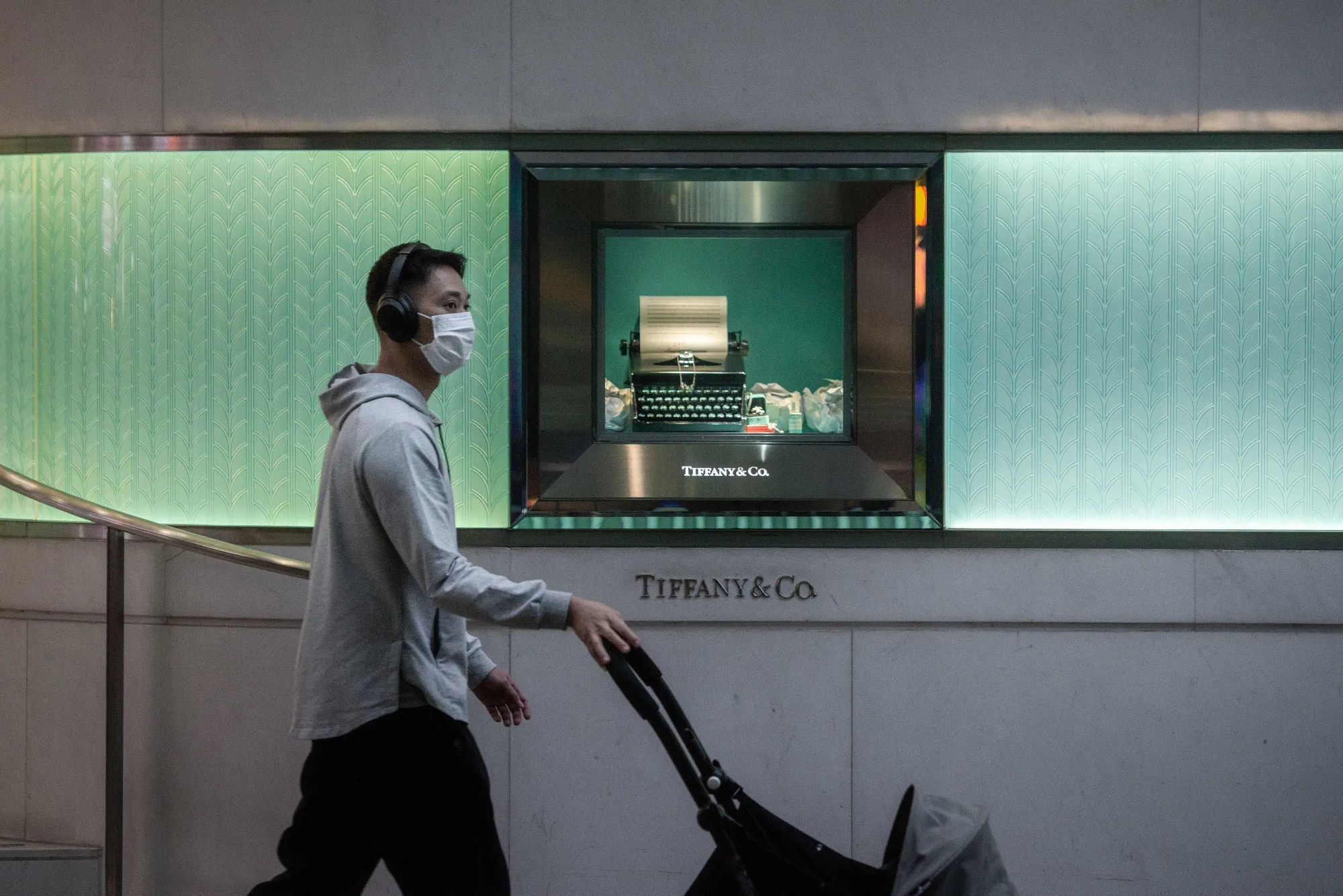 A pedestrian wears a face mask while pushing a stroller past a Tiffany &amp; Co. luxury goods store in Hong Kong, China, on Feb. 6.&nbsp;
