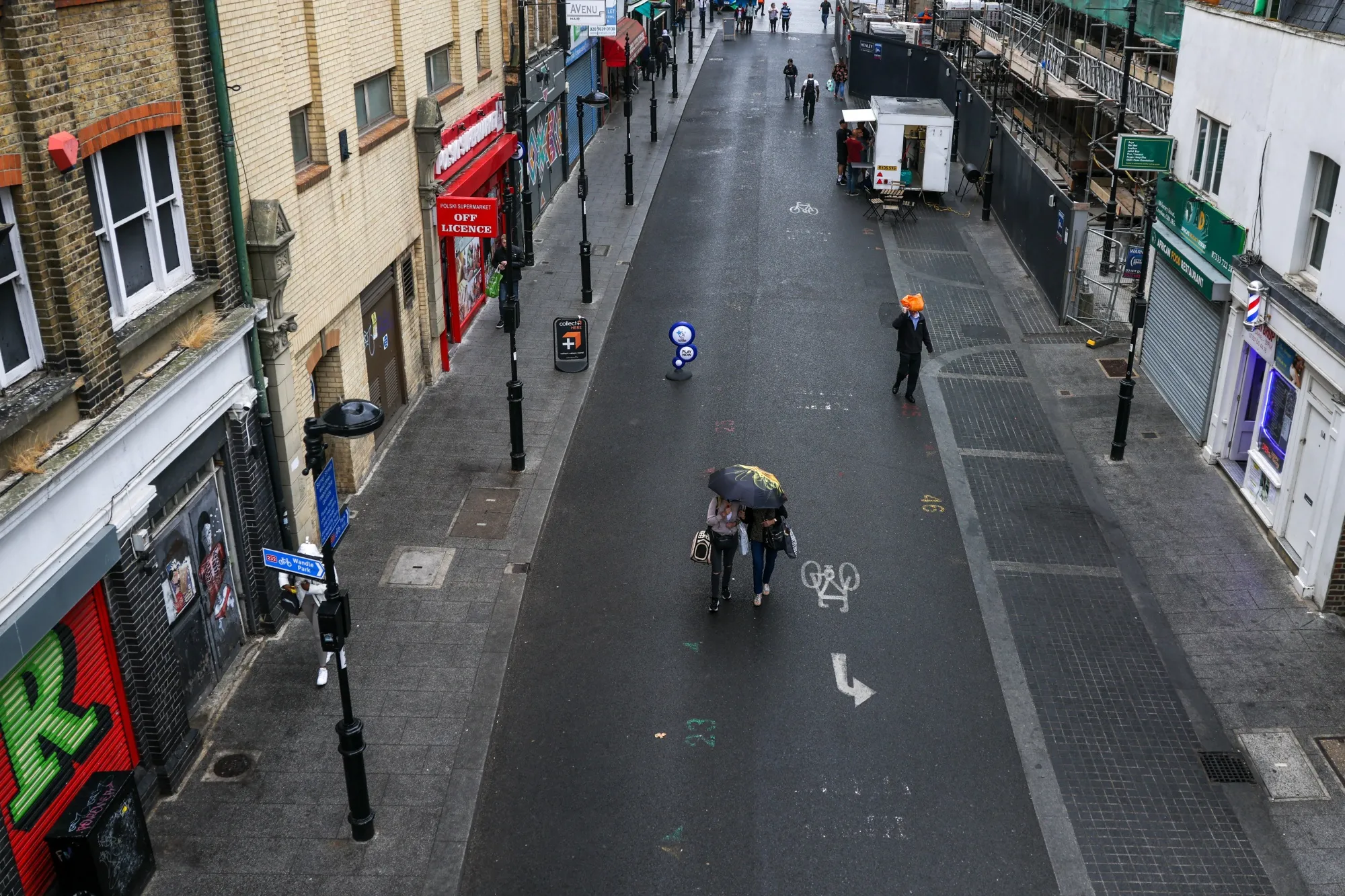 Pedestrians pass vacant spots for stall holders at Surrey Street Market in Croydon, UK.