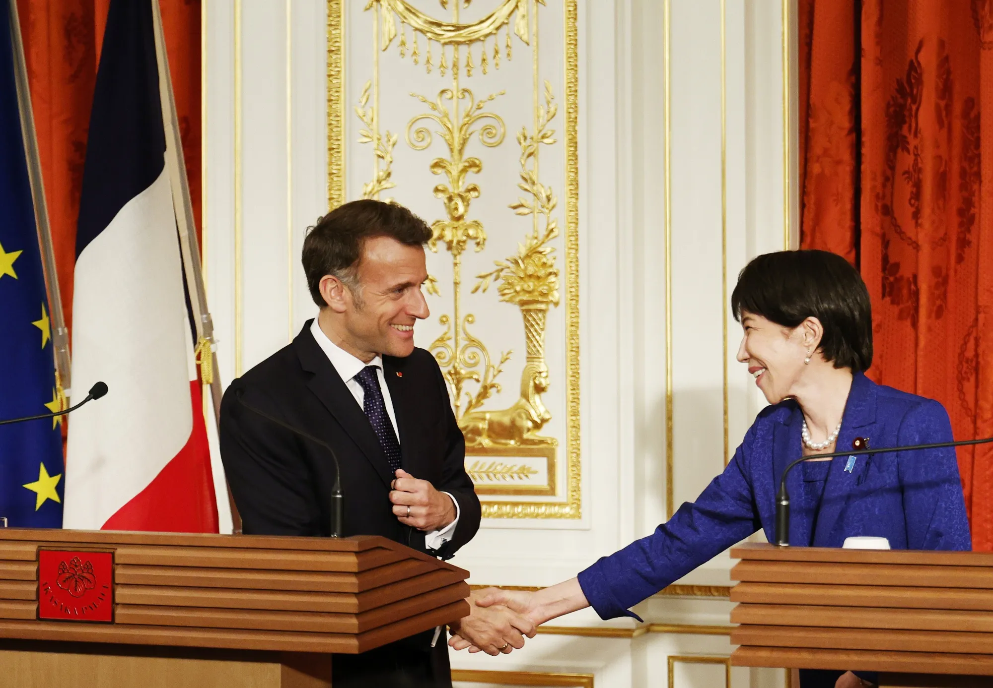 握手を交わすマクロン大統領（左）と高市首相