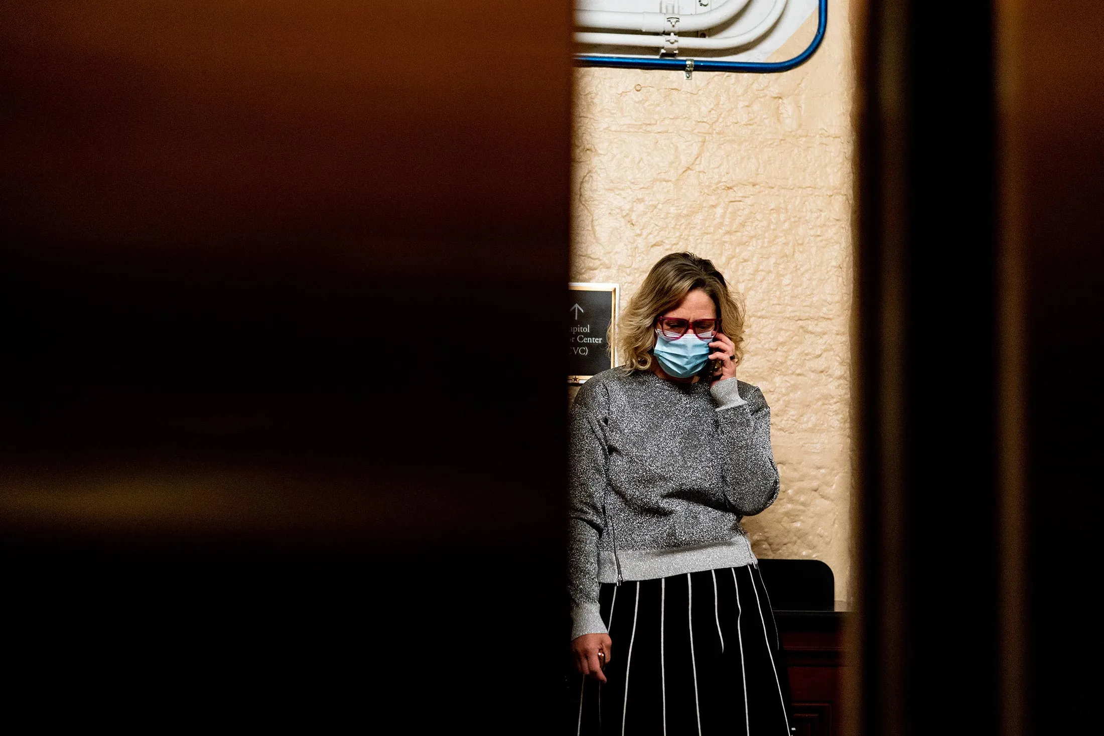 Senator Kyrsten Sinema speaks on a phone at the Capitol in Washington.
