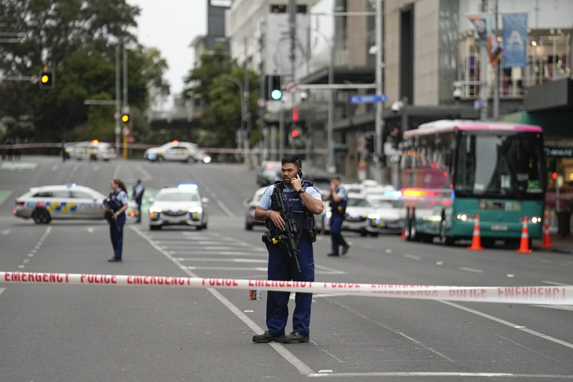 Armed New Zealand police officers stand at a road block following a shooting in Auckland on July 20.