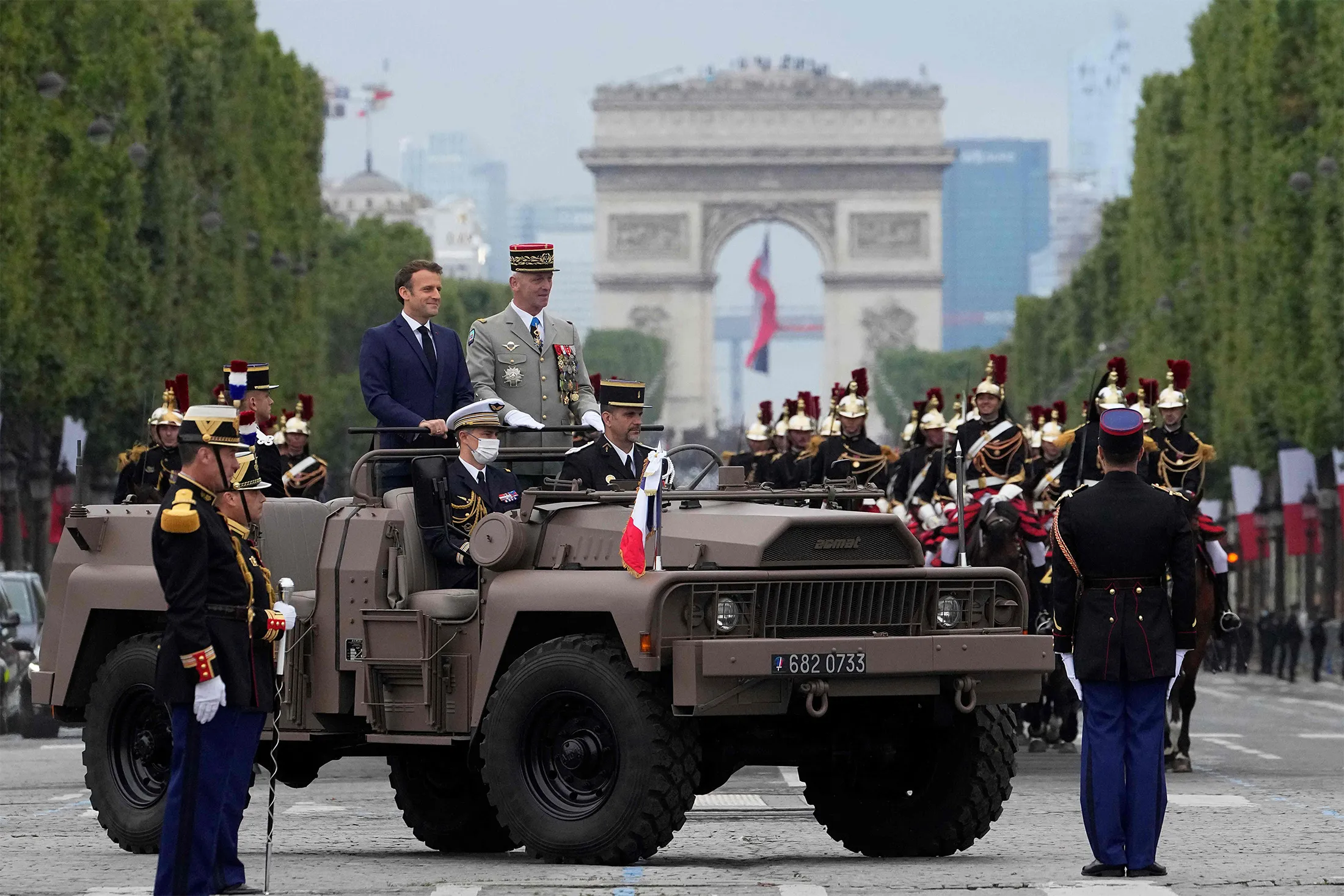 French President Emmanuel Macron, left,&nbsp;and French Armies Chief of Staff General Francois Lecointre stand in the command car during the annual Bastille Day military parade on the Champs-Elysees avenue in Paris on July 14.&nbsp;