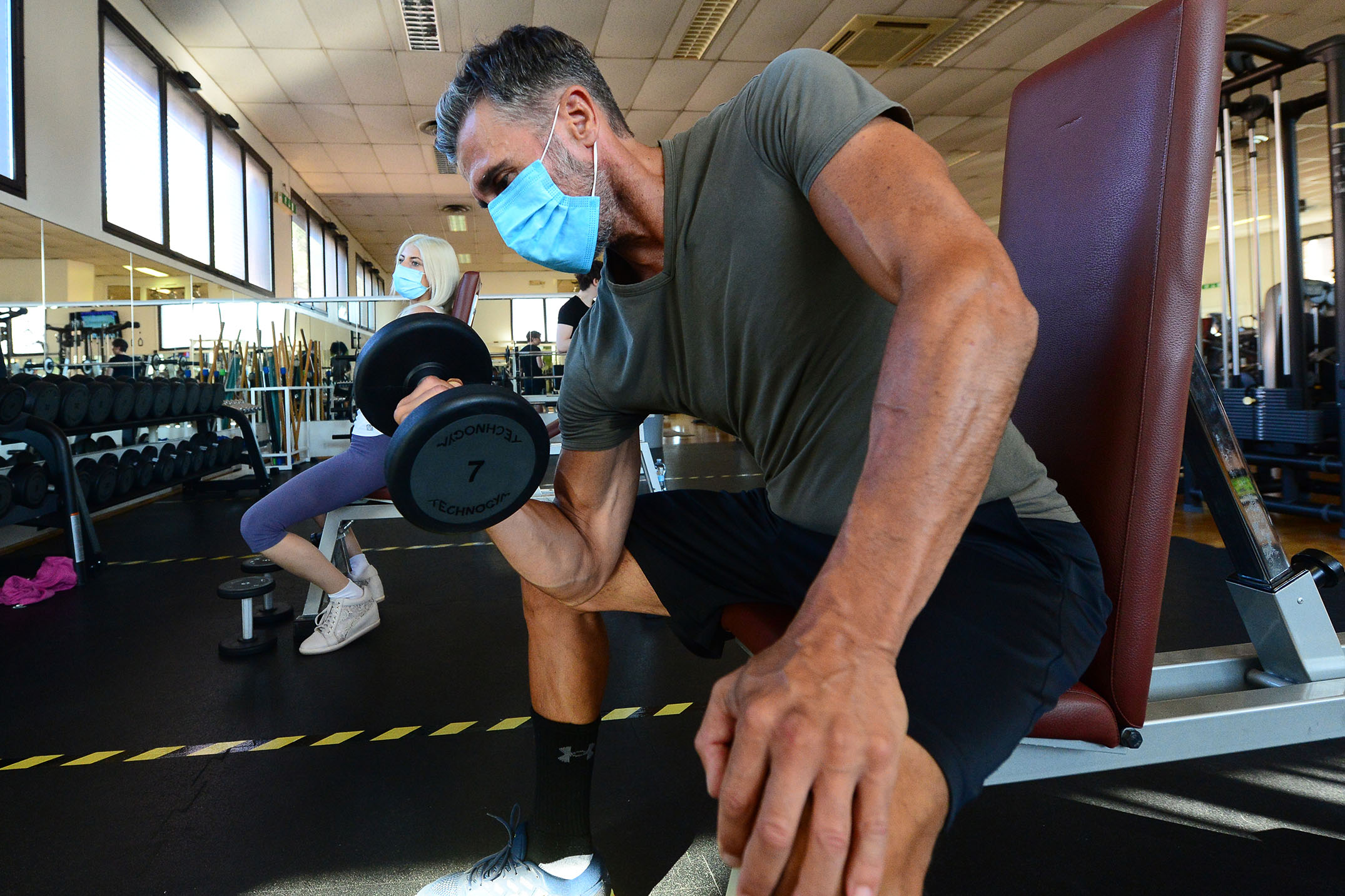 A man wears a face mask as he exercises with free weights at Bologna's Lodi Gym in Italy on May 25.