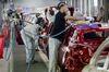 Employee carry out final inspections on the body shells of freshly painted Nissan Micra, right, and Renault Clio, second left, automobiles inside the Renault SA factory in Flins, Franc.