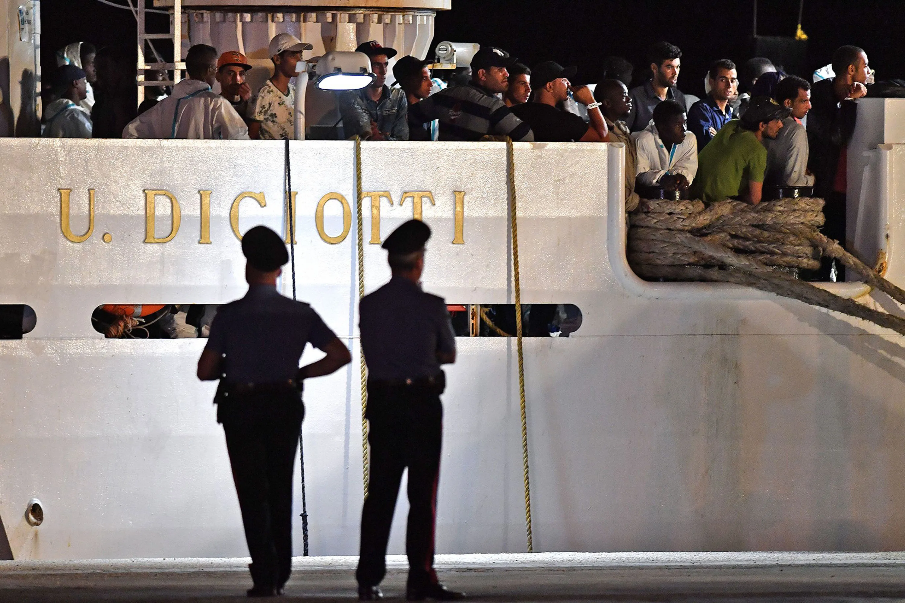 People wait to disembark from the Italian Coast Guard vessel "Diciotti",&nbsp;following a rescue operation of migrants and refugees at sea, at the port of Pozzallo, Sicily on June 19, 2018