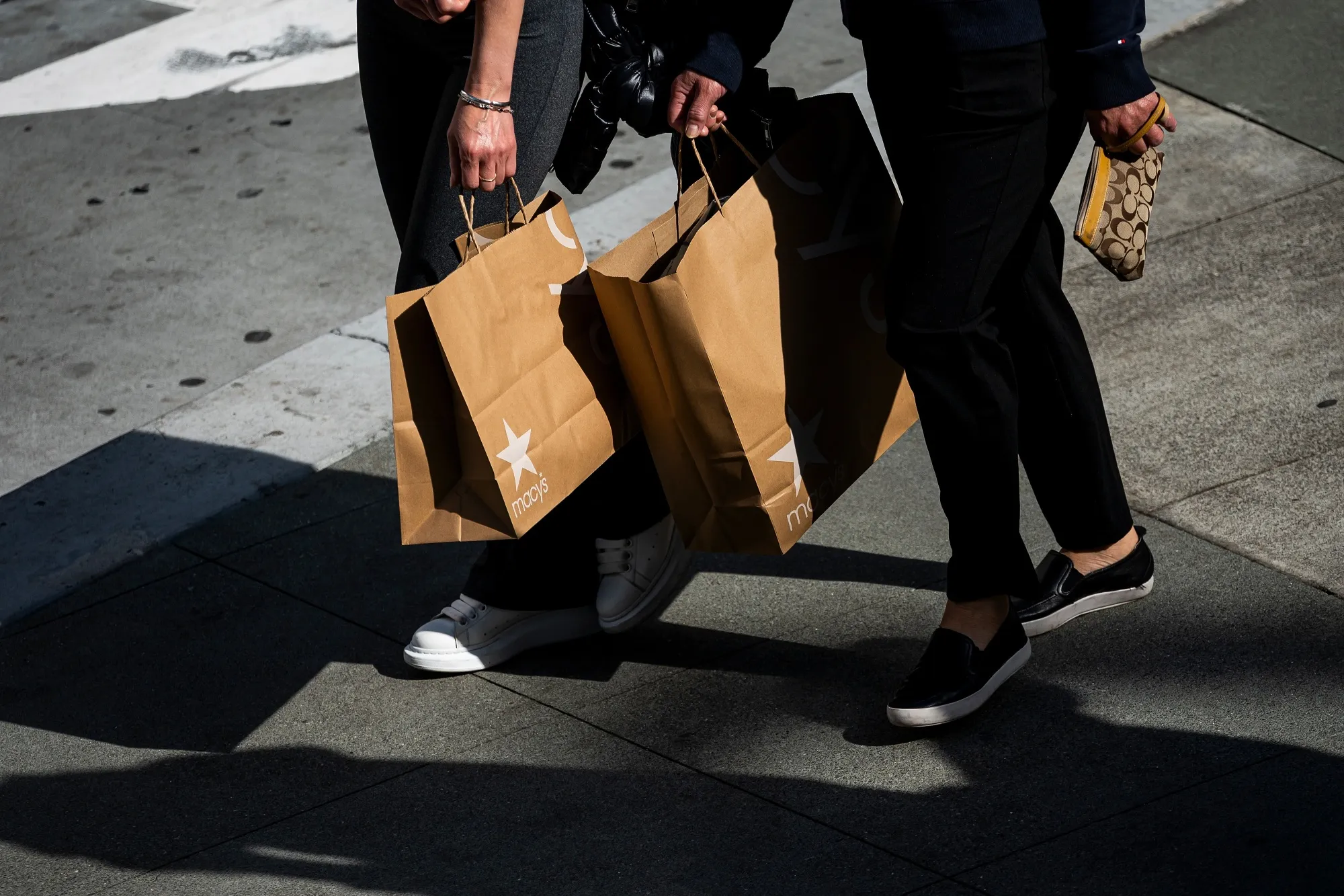 Shoppers carry Macy's bags in San Francisco in April.