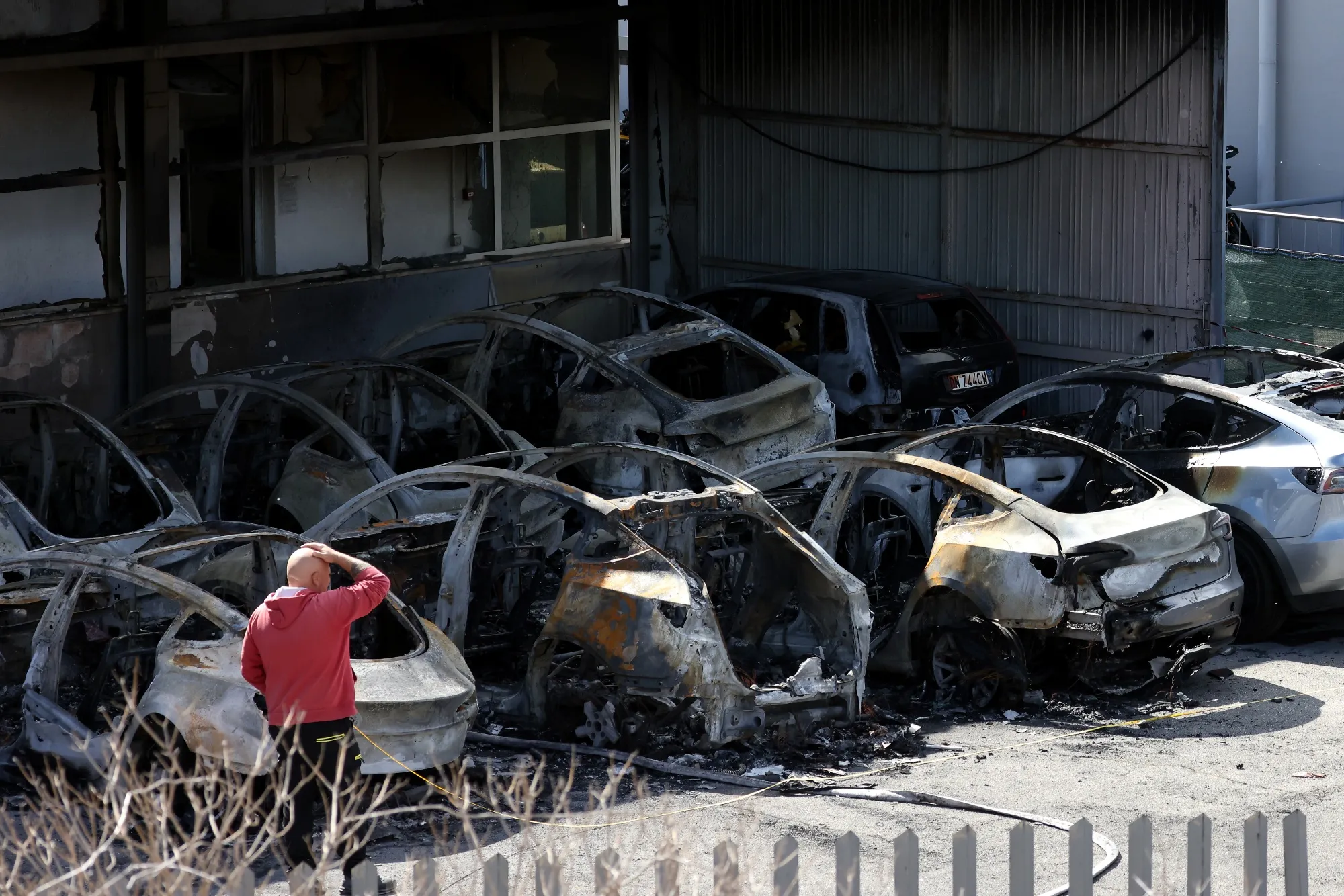 Damaged Tesla electric vehicles after a fire at a company’s dealership in Rome.