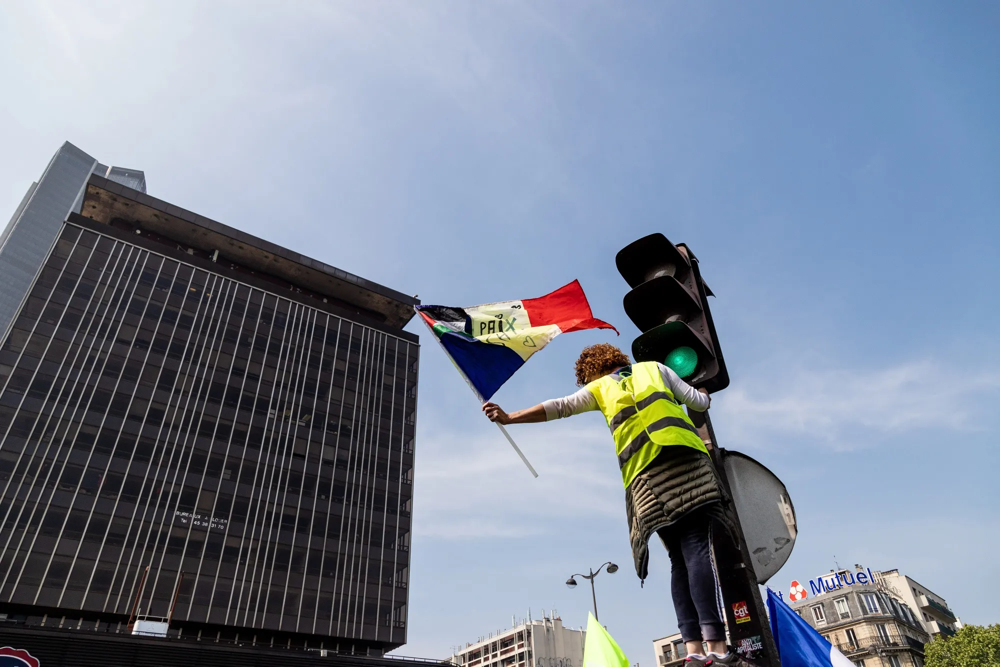 A yellow vest protester waves a French national flag on International Workers' Day in the Montparnasse district of Paris on May 1, 2019.