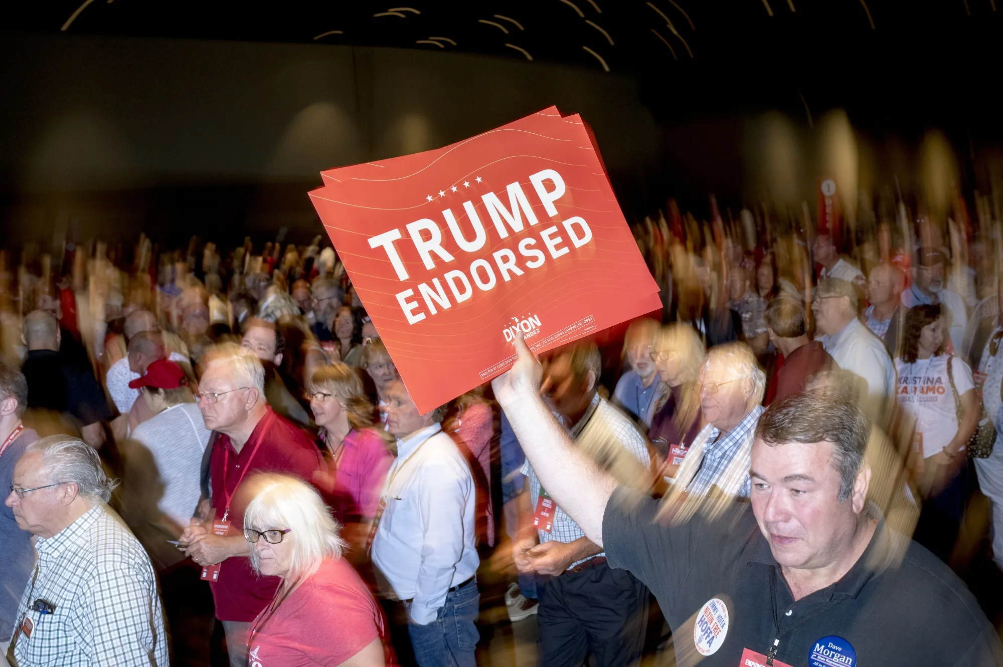 An attendee holds a campaign sign during the MIGOP Nominating Convention in Lansing, Michigan.